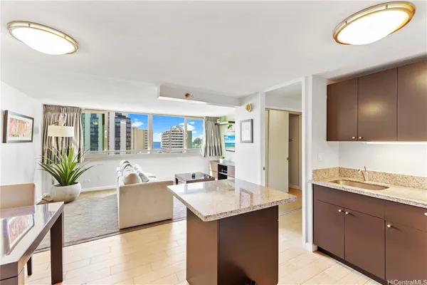 a living room with stainless steel appliances granite countertop a sink and a large window