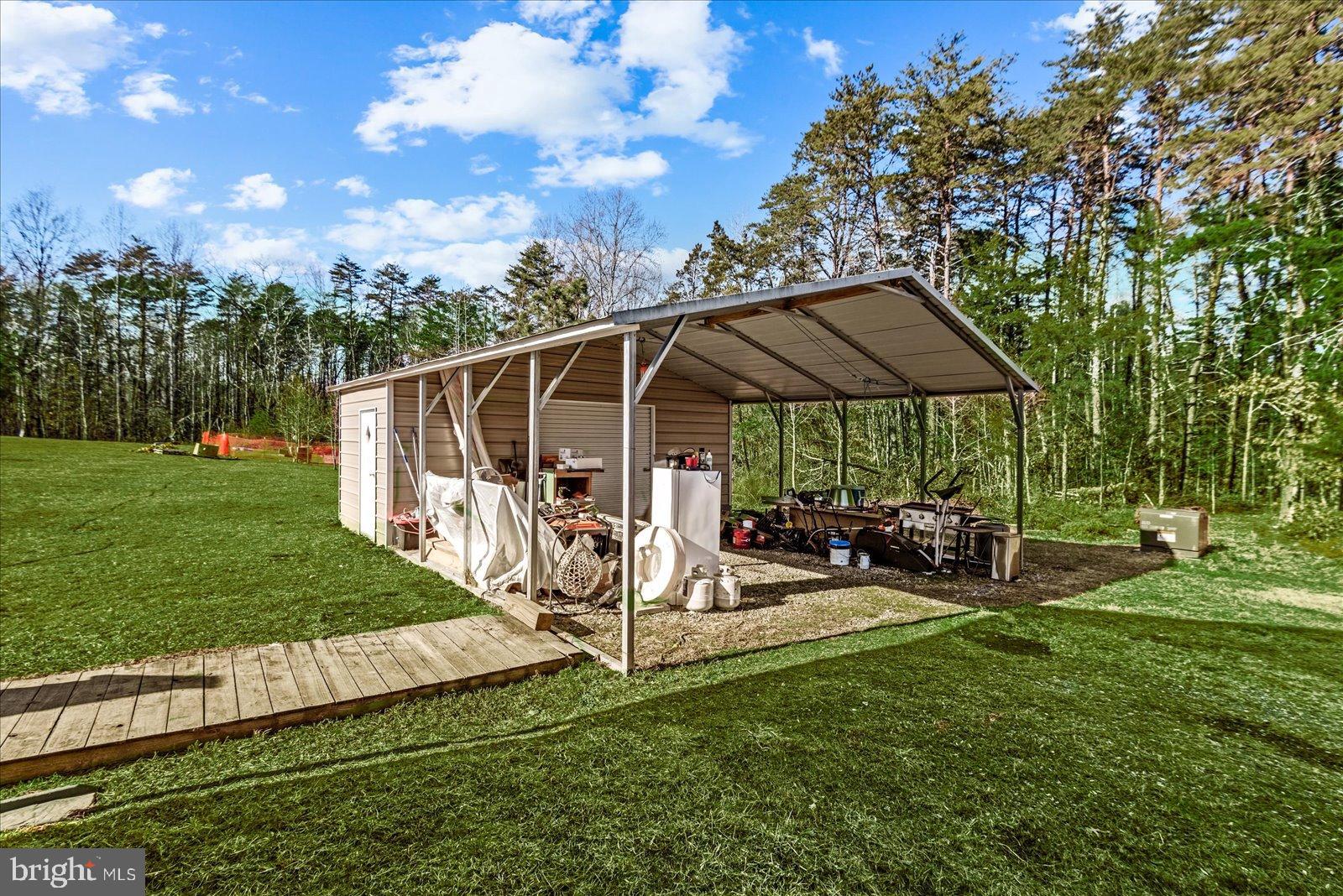 6600 Stubbs Bridge Road Spotsylvania, VA 22551 - Photo 33 of 37 Spacious shed nestled in lush greenery.