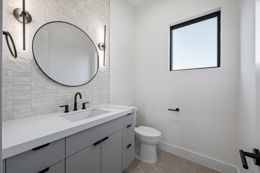 4519 Weldon Street Dallas, TX 75204 - Photo 13 of 40 a bathroom with a toilet sink and mirror