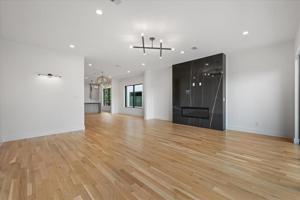 4519 Weldon Street Dallas, TX 75204 - Photo 19 of 40 a view of an empty room with wooden floor and a kitchen