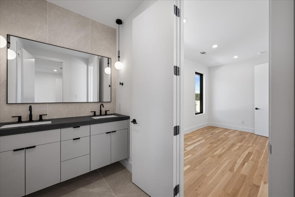 4519 Weldon Street Dallas, TX 75204 - Photo 23 of 40 a bathroom with a double vanity sink and mirror