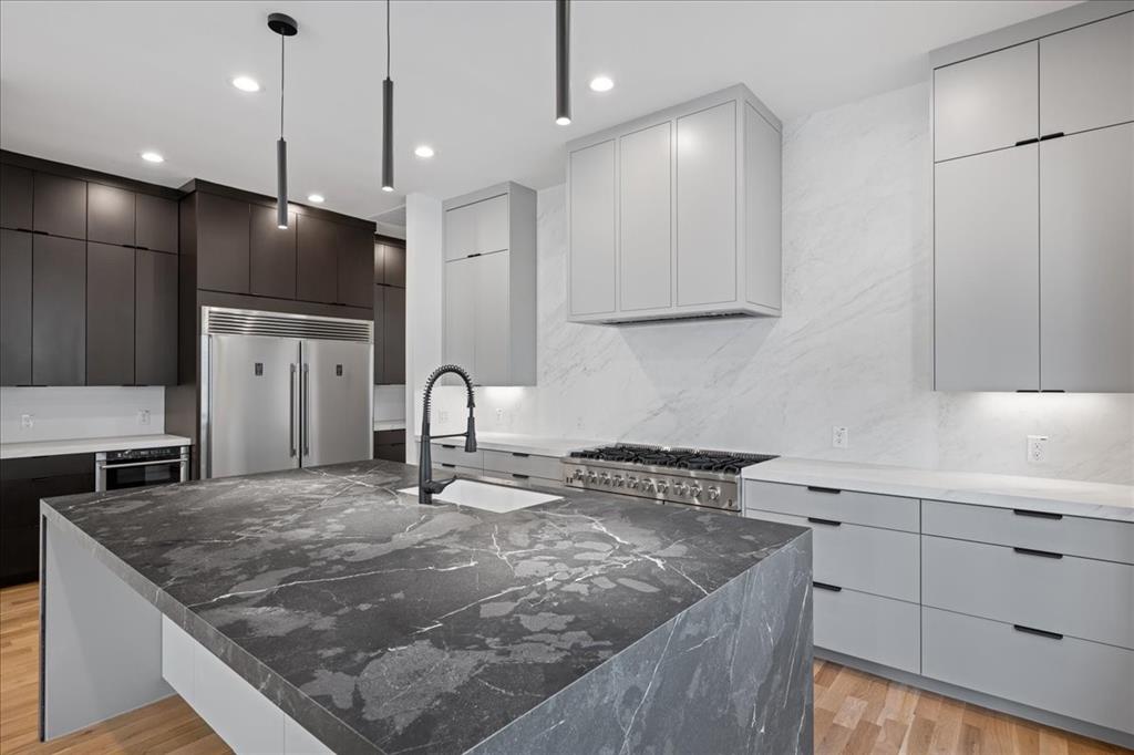 4519 Weldon Street Dallas, TX 75204 - Photo 9 of 40 a kitchen with stainless steel appliances granite countertop a sink a stove and a refrigerator