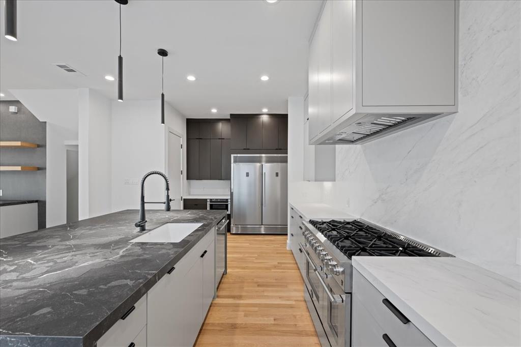 4519 Weldon Street Dallas, TX 75204 - Photo 10 of 40 a large kitchen with stainless steel appliances granite countertop a lot of counter space and wooden floor