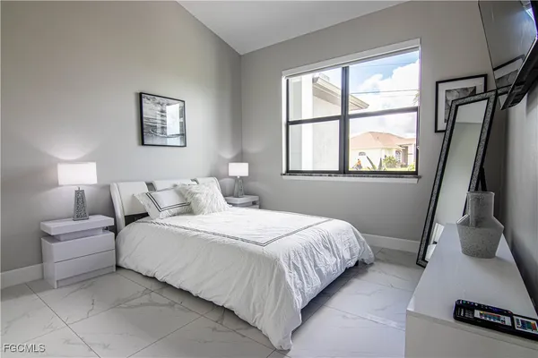 a bedroom with a bed a mirror and a window