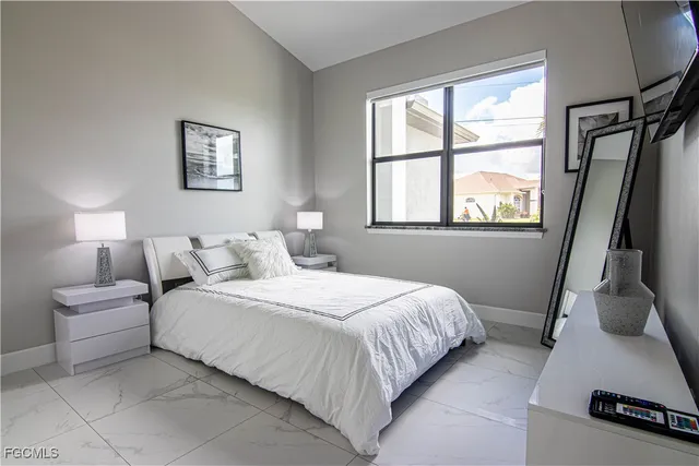 a bedroom with a bed a mirror and a window