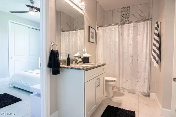 a bathroom with a sink a toilet and shower curtain
