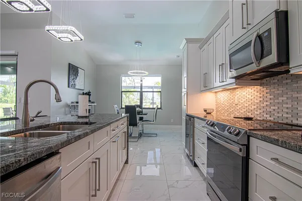 a kitchen with stainless steel appliances granite countertop a sink stove and cabinets