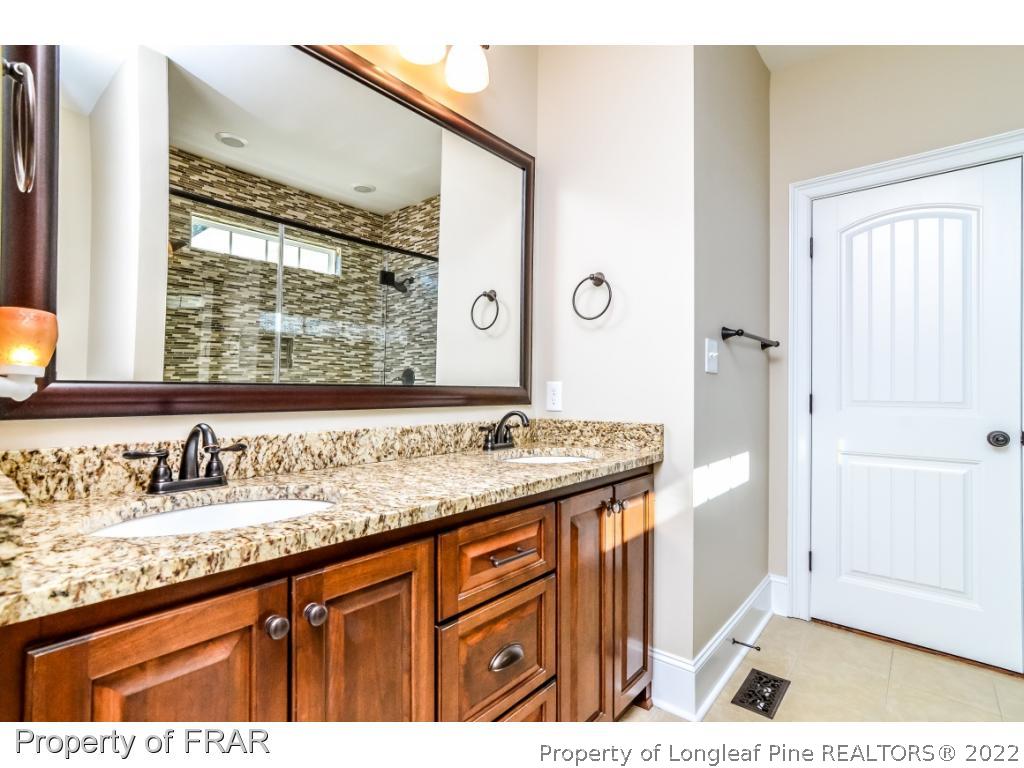 5491 Murphy Road Stedman, NC 28391 - Photo 16 of 33 a bathroom with a granite countertop sink and a mirror