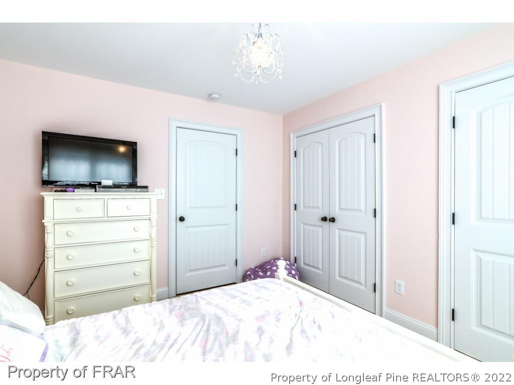 5491 Murphy Road Stedman, NC 28391 - Photo 20 of 33 a bedroom with a bed and a flat screen tv