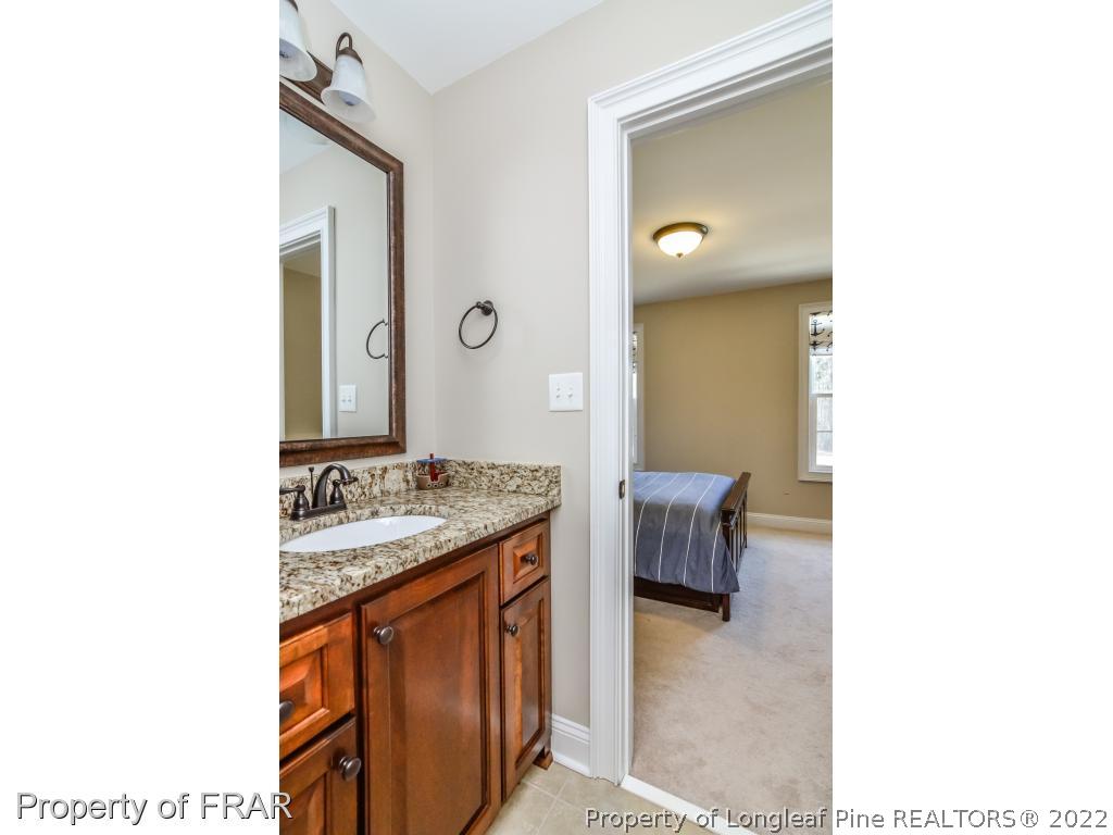 5491 Murphy Road Stedman, NC 28391 - Photo 25 of 33 a en suite bathroom with a granite countertop sink and a mirror