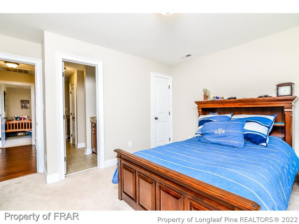 5491 Murphy Road Stedman, NC 28391 - Photo 26 of 33 a bedroom with a bed and a chandelier