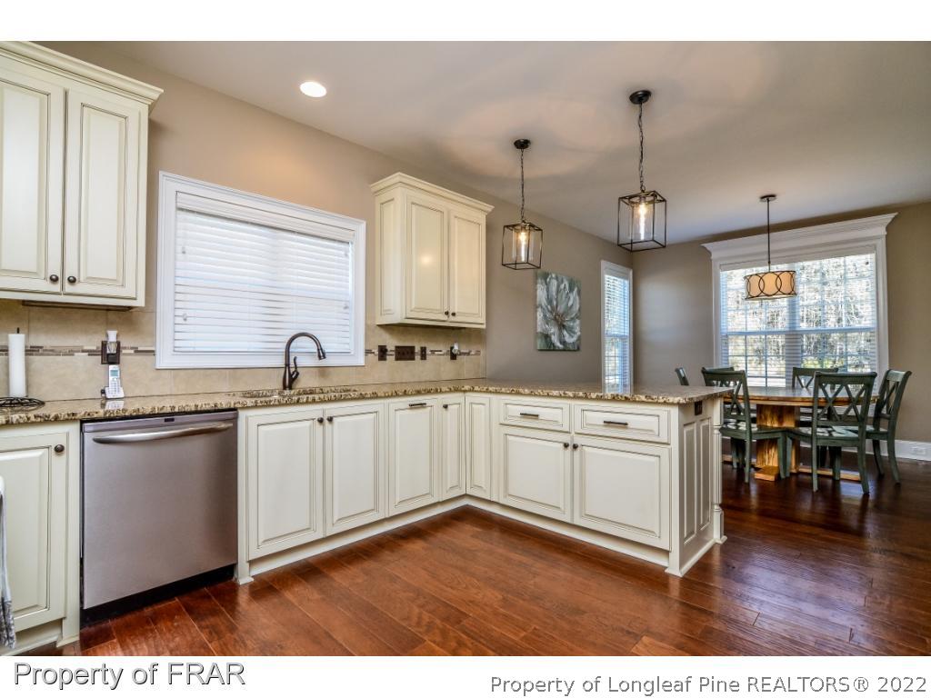 5491 Murphy Road Stedman, NC 28391 - Photo 7 of 33 a kitchen with stainless steel appliances granite countertop wooden floors and white cabinets