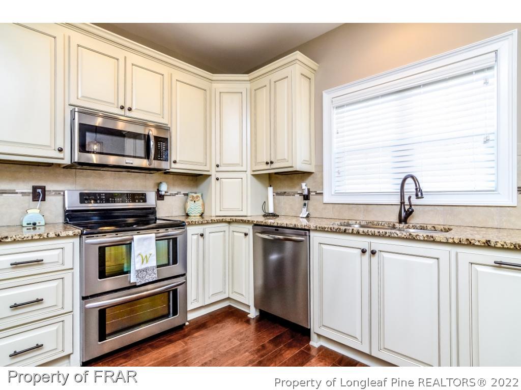 5491 Murphy Road Stedman, NC 28391 - Photo 8 of 33 a kitchen with stainless steel appliances granite countertop a sink and a stove