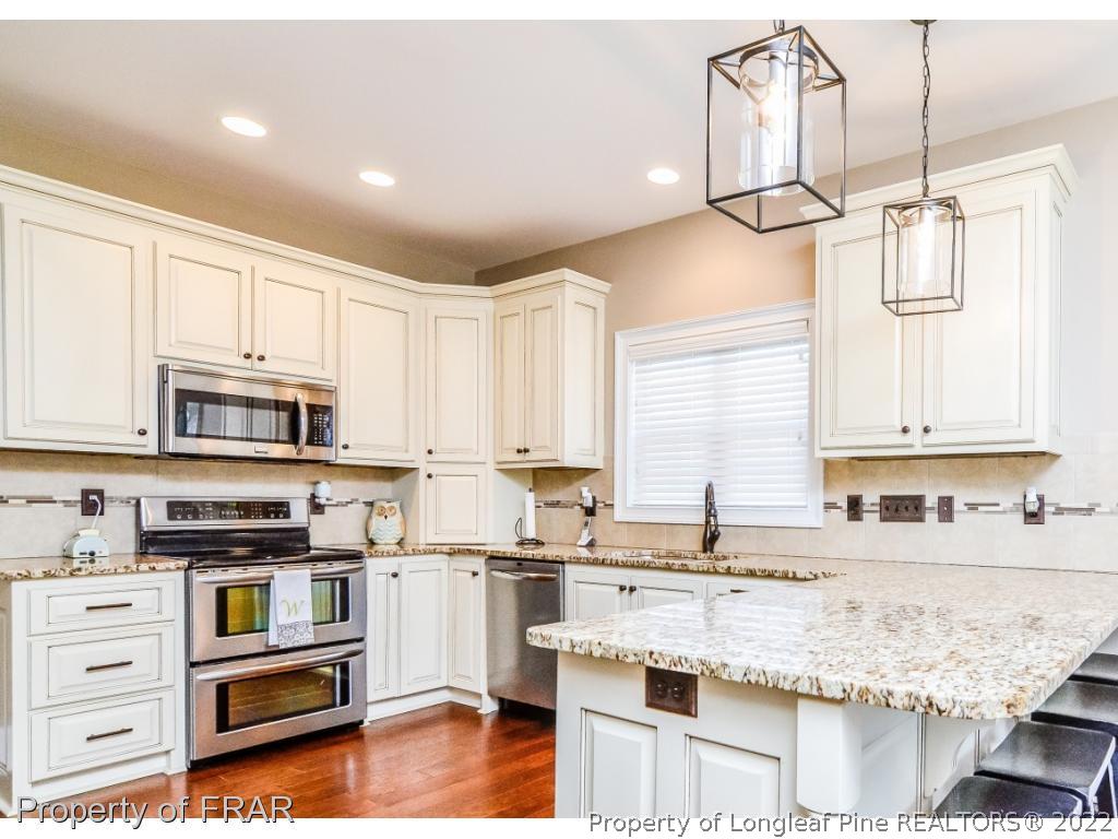 5491 Murphy Road Stedman, NC 28391 - Photo 10 of 33 a kitchen with granite countertop a sink counter top space appliances and cabinets