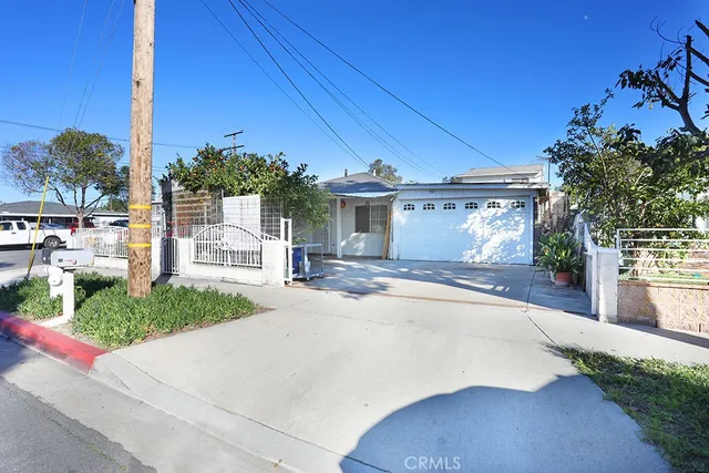 a front view of a house with a yard and potted plants