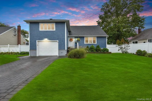 a front view of a house with a garden and yard
