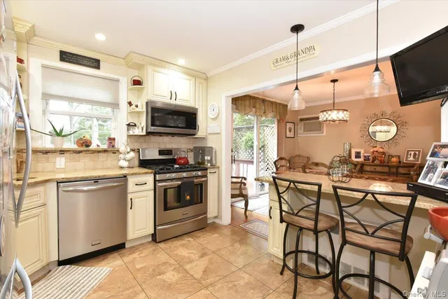 a kitchen with stainless steel appliances granite countertop a stove top oven a sink dishwasher and a refrigerator with wooden floor