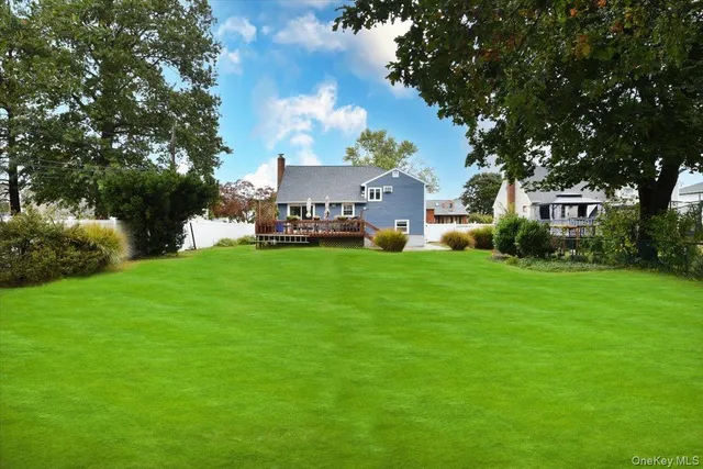 a view of a house with a big yard and large trees