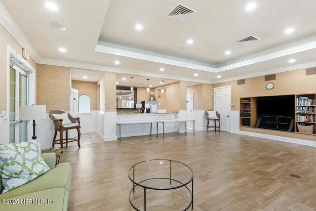 a view of a swimming pool with a lawn chairs and palm tree