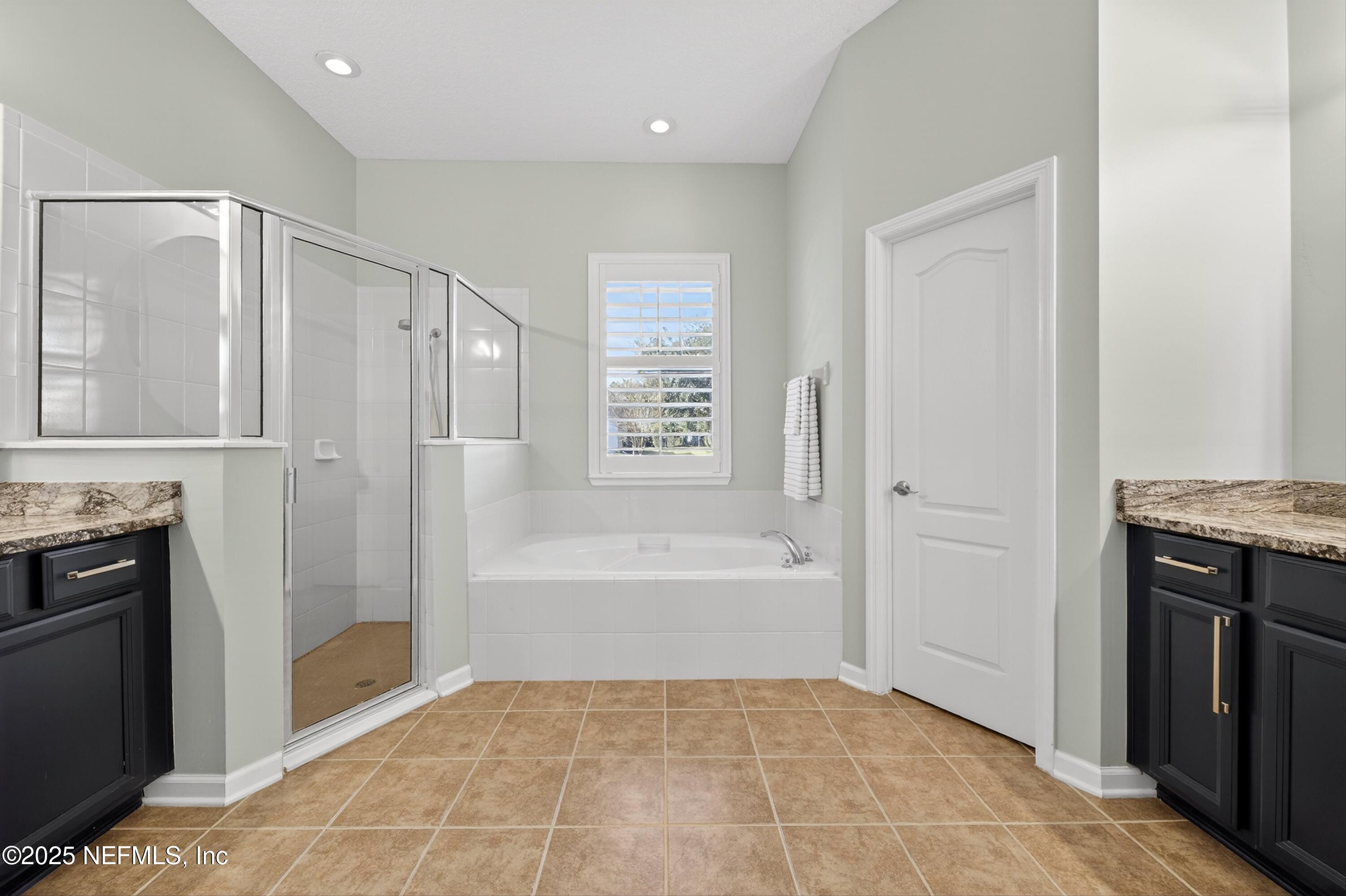 1104 Westfield Way St. Augustine, FL 32095 - Photo 14 of 53 a spacious bathroom with a granite countertop bathtub a shower and a sink