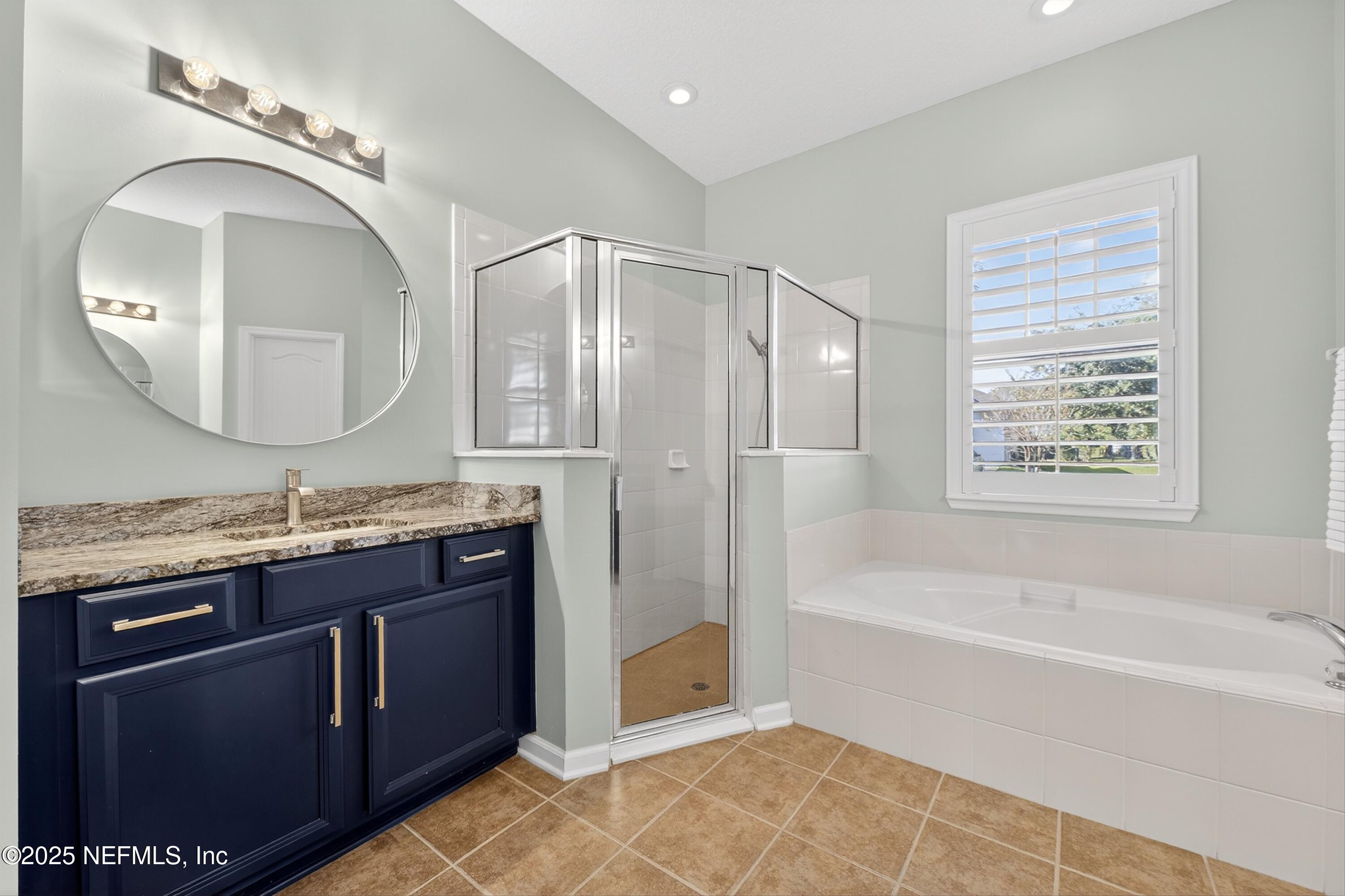 1104 Westfield Way St. Augustine, FL 32095 - Photo 16 of 53 a spacious bathroom with a granite countertop sink a mirror a bathtub and shower