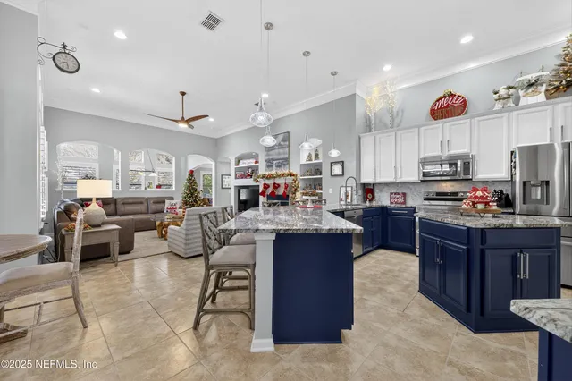 a kitchen with stainless steel appliances granite countertop a stove top oven a sink dishwasher and a refrigerator