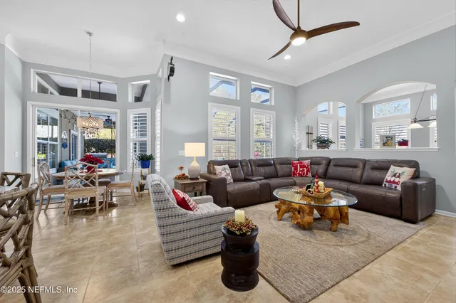 a living room with furniture a rug and a ceiling fan