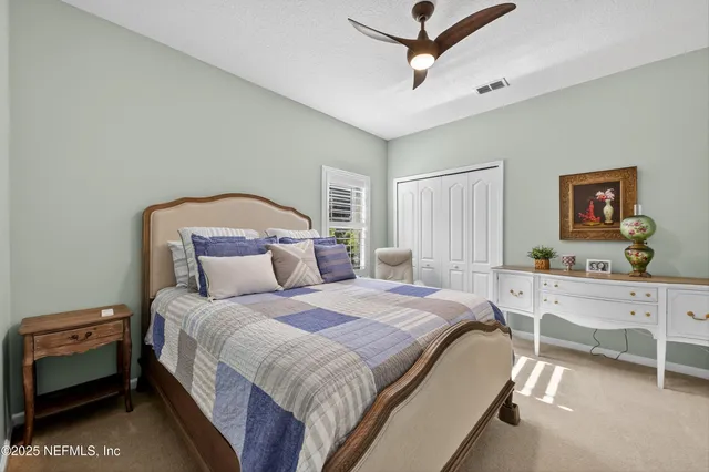 a bedroom with a bed and a painting on the wall