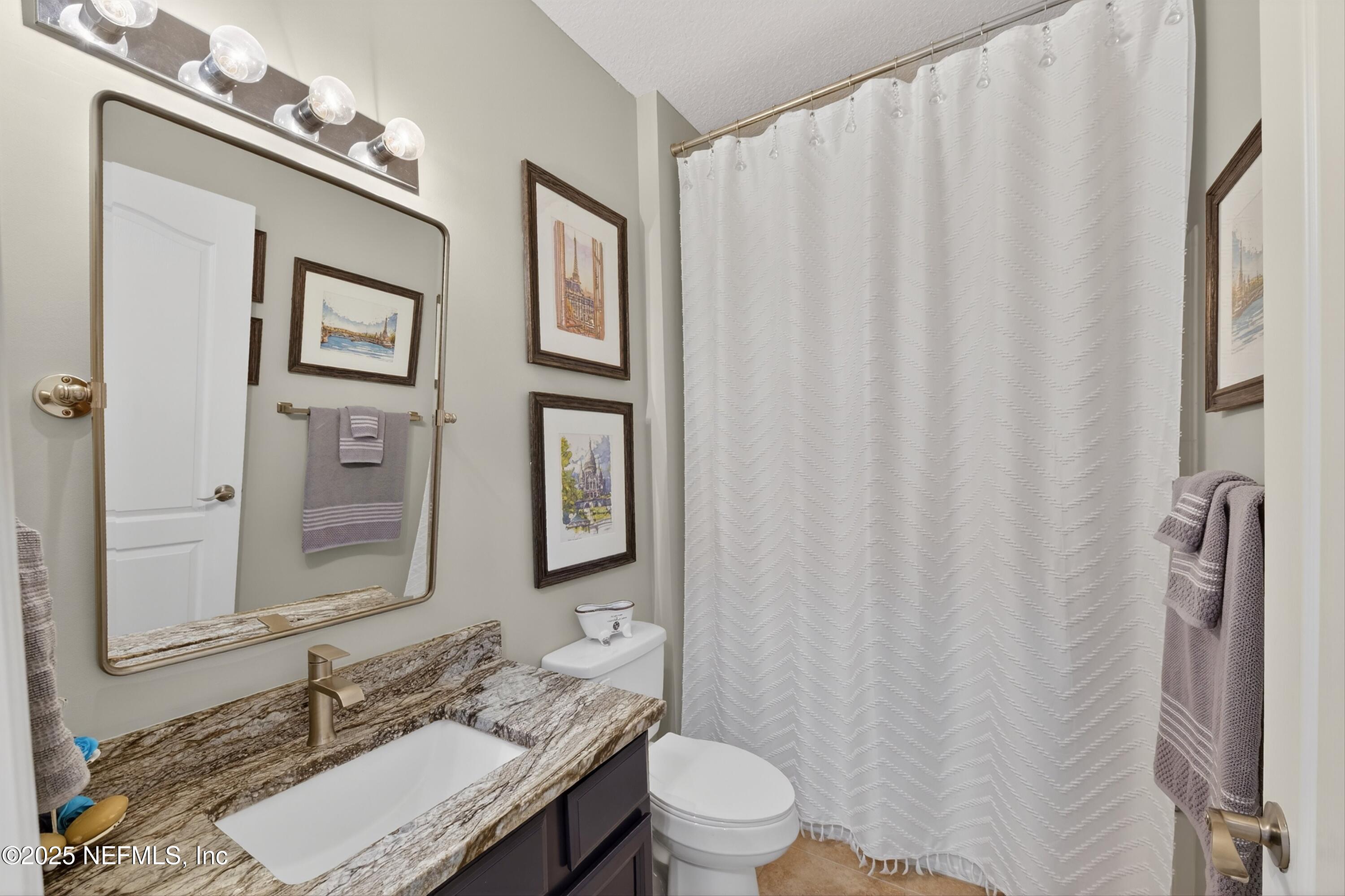 1104 Westfield Way St. Augustine, FL 32095 - Photo 35 of 53 a bathroom with a granite countertop sink toilet and mirror