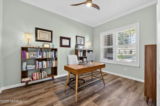 a living room with furniture a bookshelf and a window