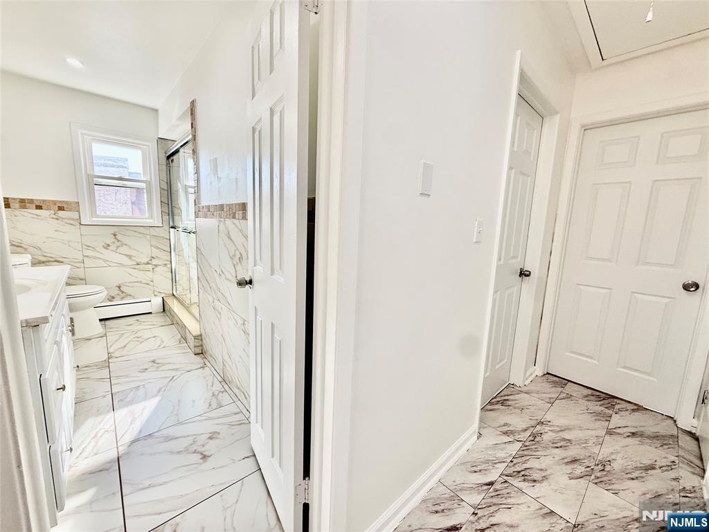41 Corabelle Avenue, Unit 2 Lodi, NJ 07644 - Photo 12 of 21 a view of a hallway with wooden floor and cabinet space