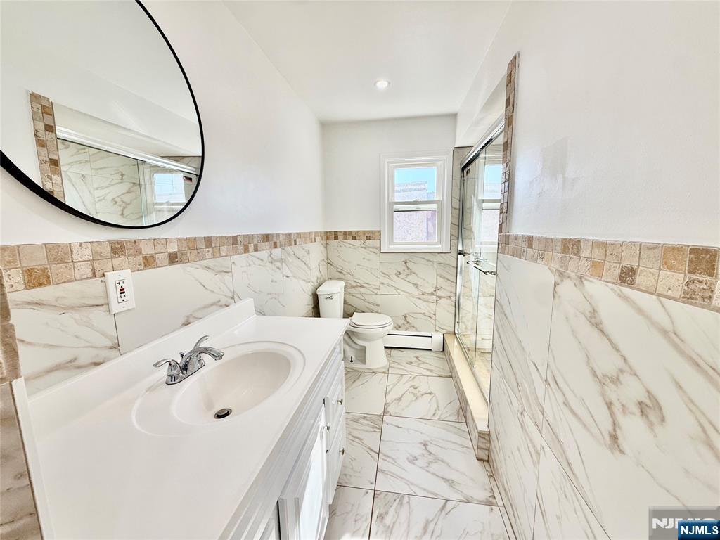 41 Corabelle Avenue, Unit 2 Lodi, NJ 07644 - Photo 13 of 21 a bathroom with a sink and a mirror