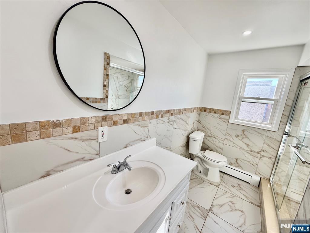 41 Corabelle Avenue, Unit 2 Lodi, NJ 07644 - Photo 14 of 21 a bathroom with a sink and a mirror