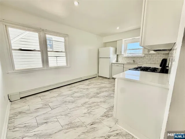 a kitchen with a refrigerator a stove a microwave and cabinets
