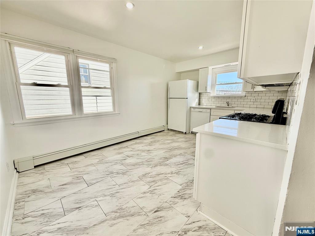 41 Corabelle Avenue, Unit 2 Lodi, NJ 07644 - Photo 8 of 21 a kitchen with a refrigerator a stove a microwave and cabinets