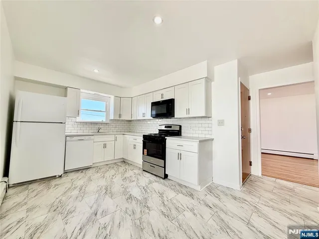 a kitchen with stainless steel appliances refrigerator stove microwave and cabinets