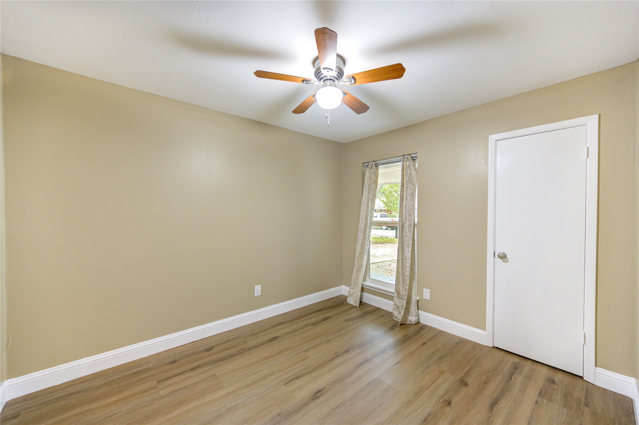 1921 Ripple Creek Drive Rosenberg, TX 77471 - Photo 14 of 17 an empty room with wooden floor fan and windows