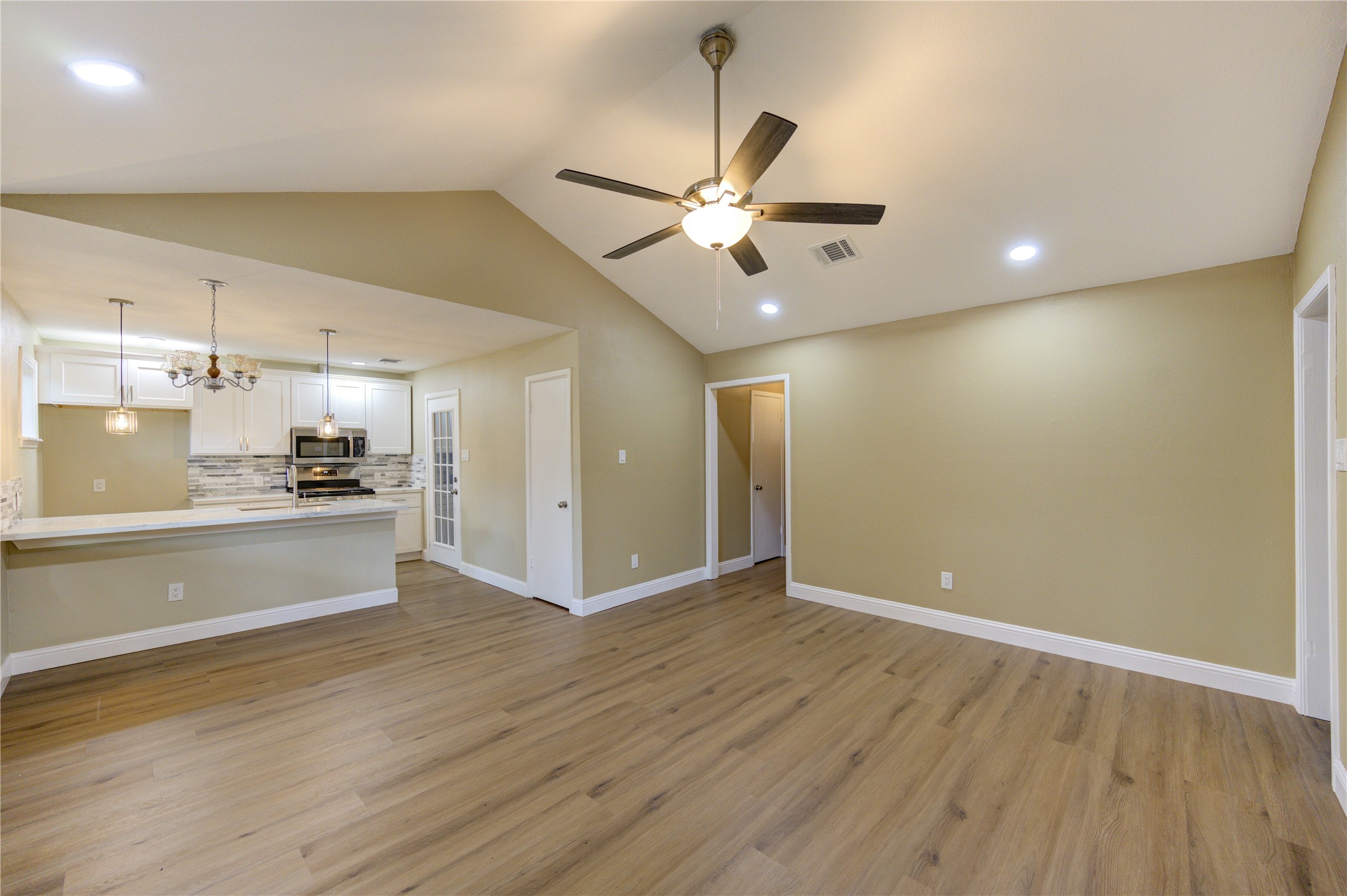 1921 Ripple Creek Drive Rosenberg, TX 77471 - Photo 7 of 17 a view of an empty room and kitchen with wooden floor