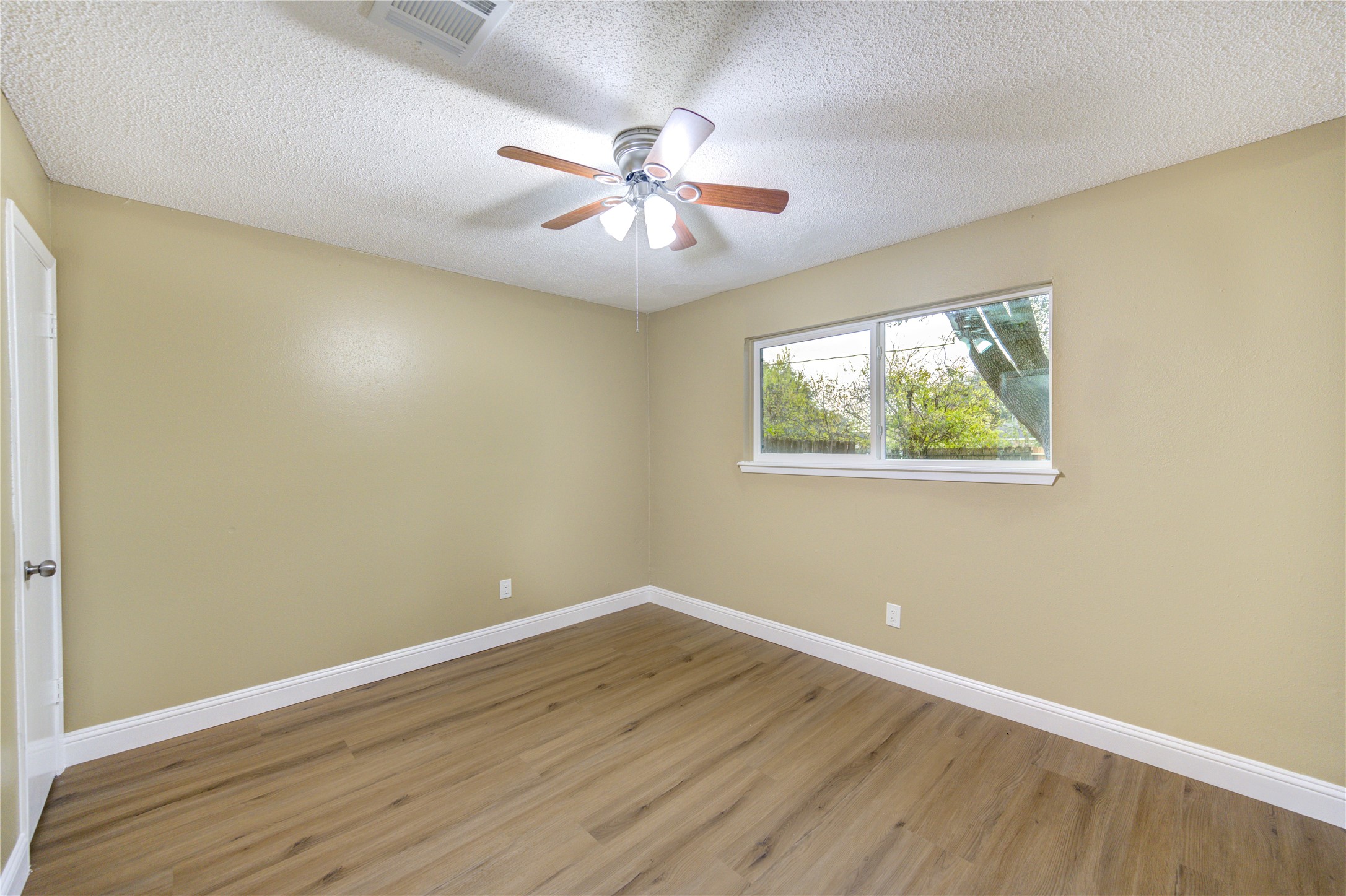 1921 Ripple Creek Drive Rosenberg, TX 77471 - Photo 9 of 17 a view of an empty room with wooden floor and a ceiling fan