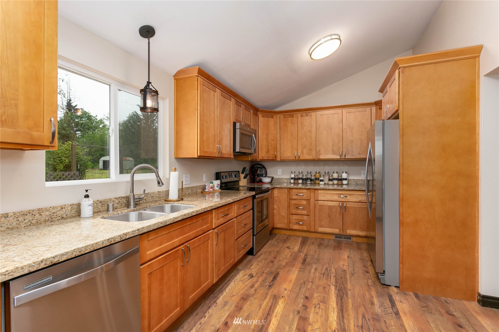 15722 240th Street East Graham, WA 98338 - Photo 15 of 40 a kitchen with stainless steel appliances granite countertop a sink window and cabinets