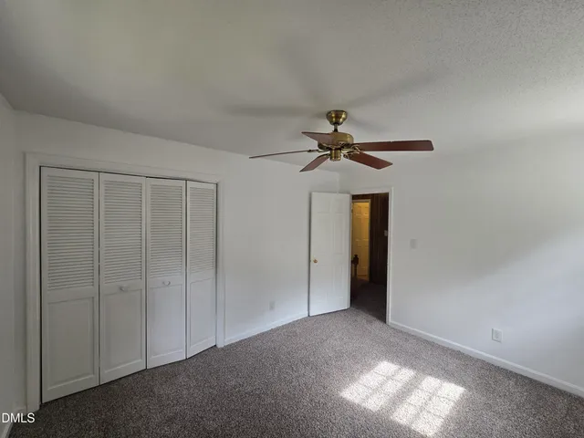 a view of a livingroom with a chandelier fan and closet