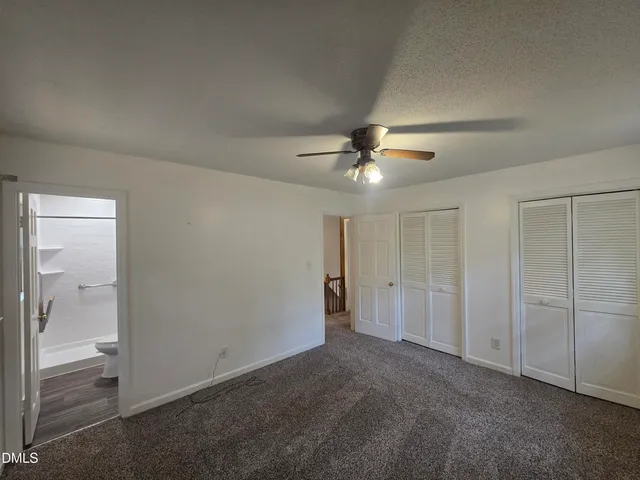 an empty room with closet and a chandelier fan