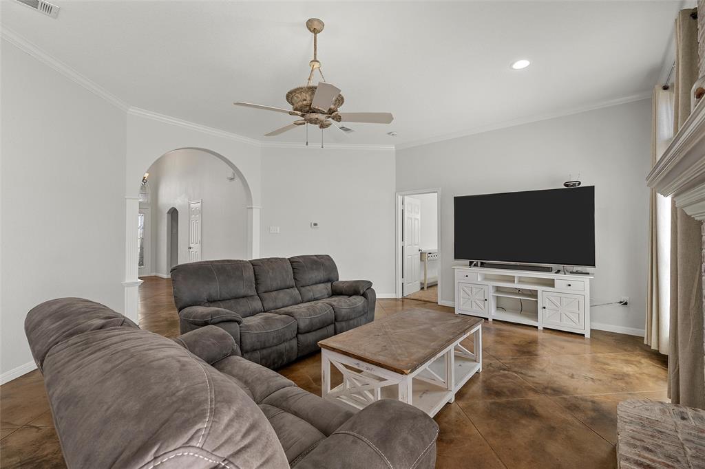3696 Old Lorena Road Lorena, TX 76655 - Photo 6 of 27 Living area featuring warm-toned concrete flooring, vaulted ceiling, and crown molding