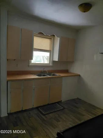 a kitchen with granite countertop a sink window and cabinets