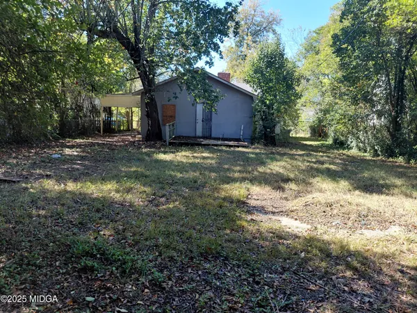 a view of a house with backyard and trees
