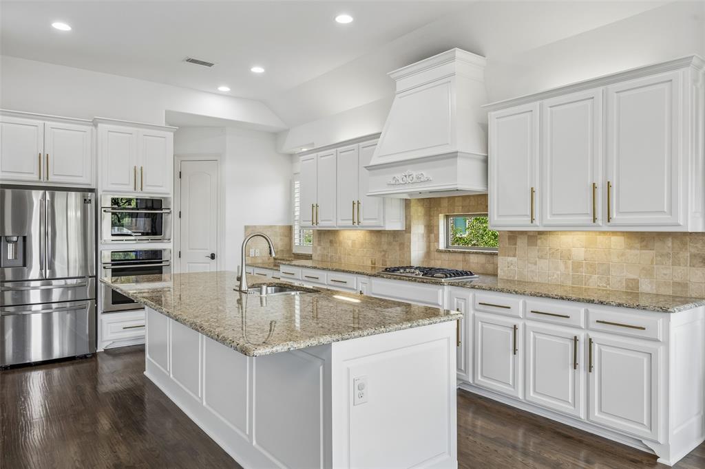 134 Santa Rosa Way Irving, TX 75062 - Photo 5 of 26 Chef’s kitchen featuring an oversized island, abundant cabinetry, granite countertops, and stainless steel appliances.