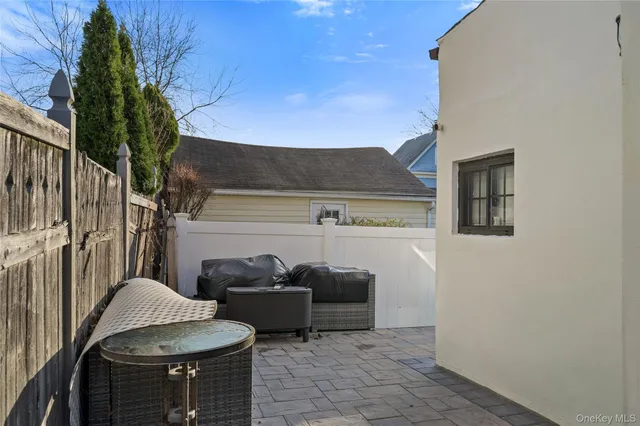 a view of a patio with table and chairs potted plants and wooden fence