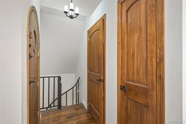 a view of a hallway with entryway and chandelier