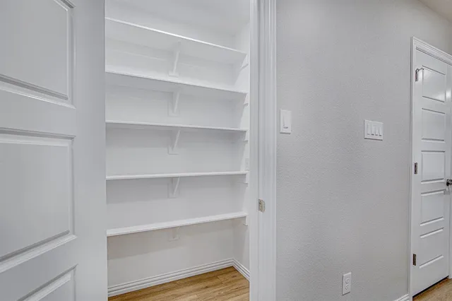 a view of walk in closet with empty racks