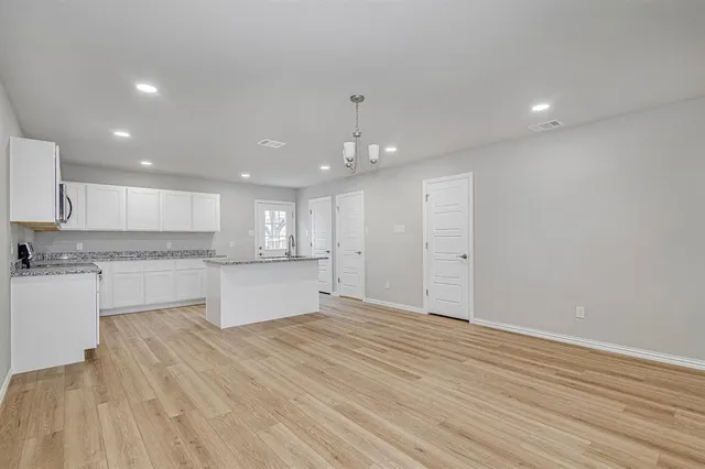 a large kitchen with kitchen island a sink stainless steel appliances and cabinets